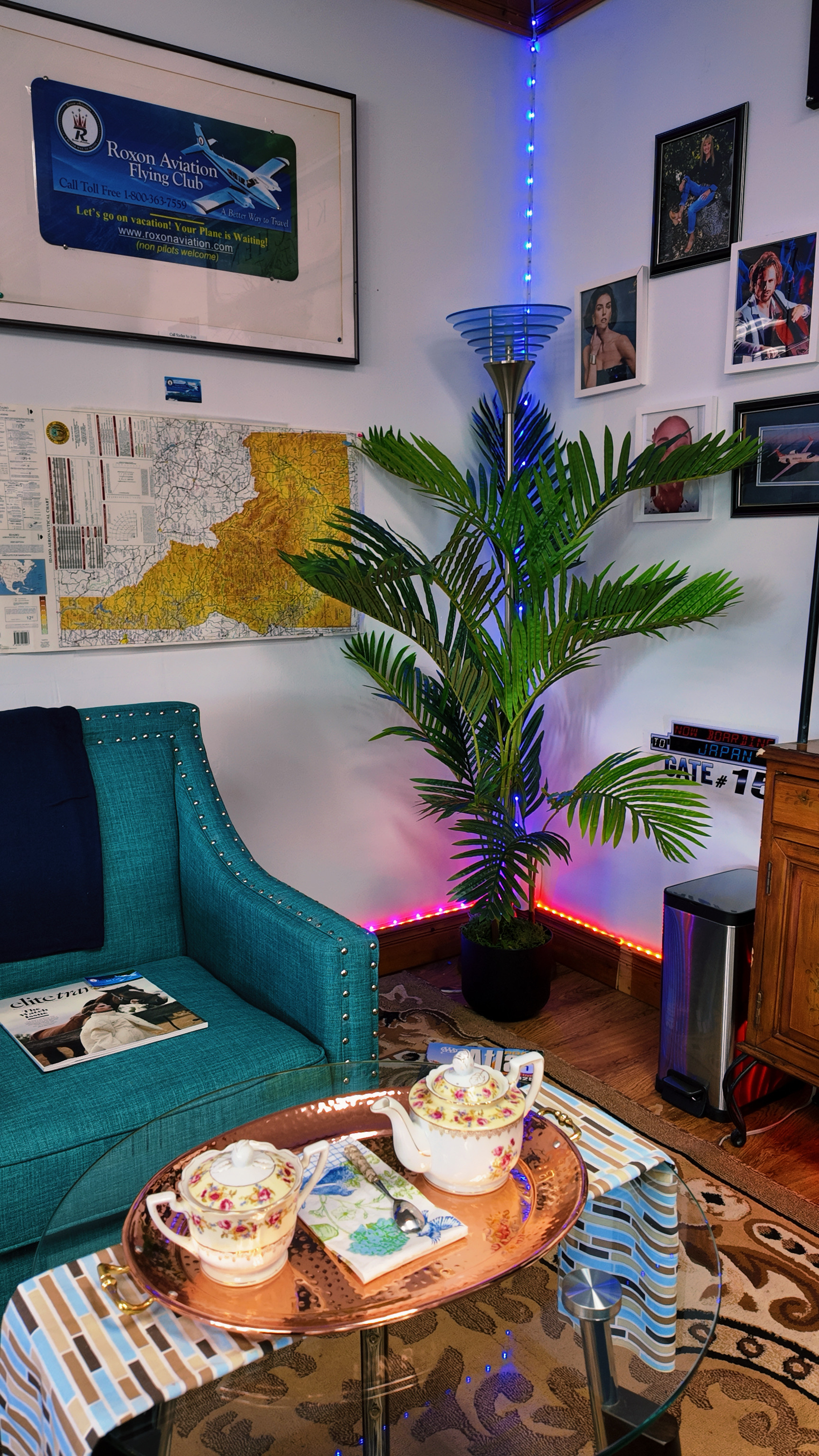 Jet Cafe cozy aviation-themed interior with teal armchairs and palm plants