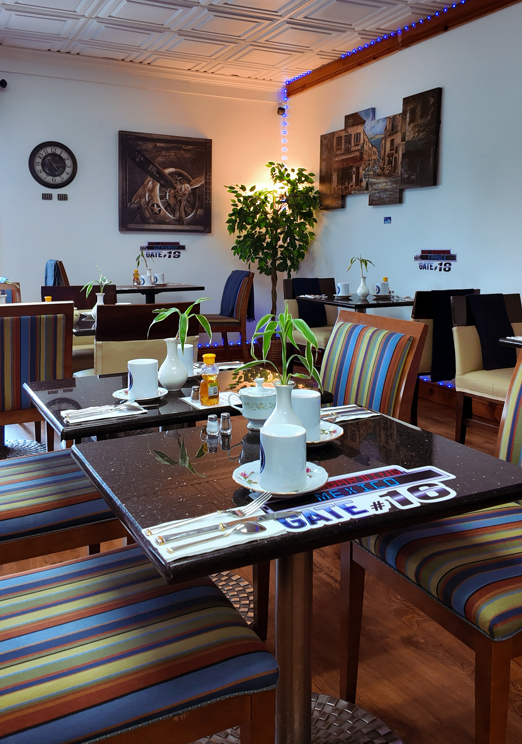 Jet Cafe dining area with colorful striped chairs, table settings, and aviation gate signs