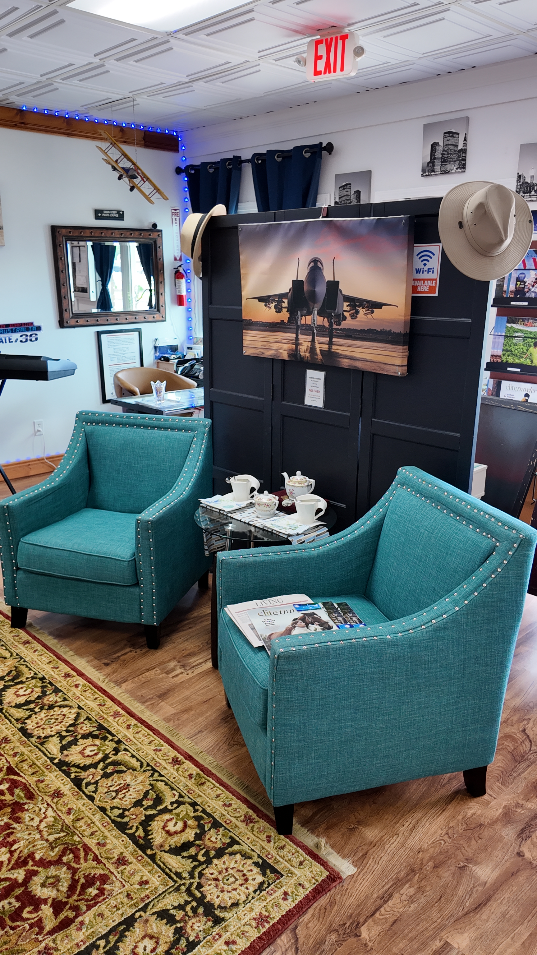 Comfortable teal lounge chairs in Jet Cafe with fighter jet artwork and model airplane decor
